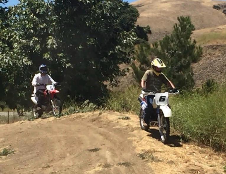 Two riders descending a gentle hill on the training trail