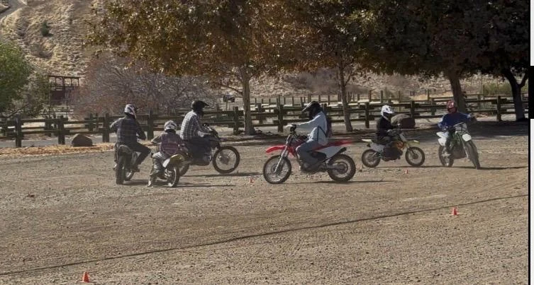Dirt bike students practicing turns together on the training course