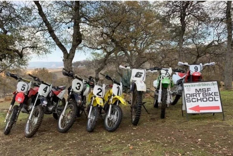 Loaner dirt bikes of different sizes beside the MSF DirtBike School sign