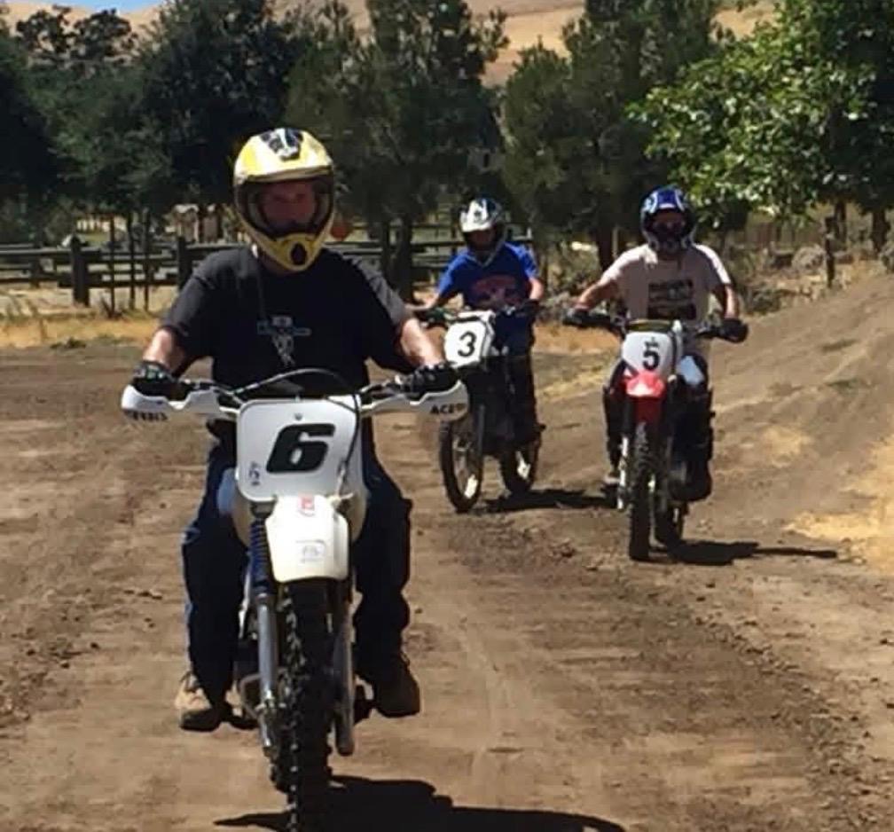 Three dirt bike riders riding in formation on the training course
